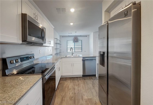 kitchen featuring white cabinets, pendant lighting, appliances with stainless steel finishes, and sink