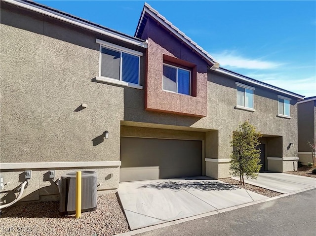 view of front of home with a garage and central air condition unit