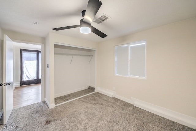 unfurnished bedroom featuring ceiling fan, a closet, and light carpet