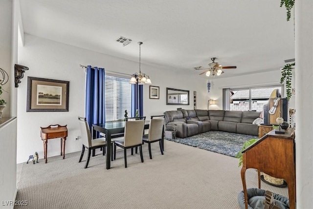 dining room featuring ceiling fan with notable chandelier and carpet floors