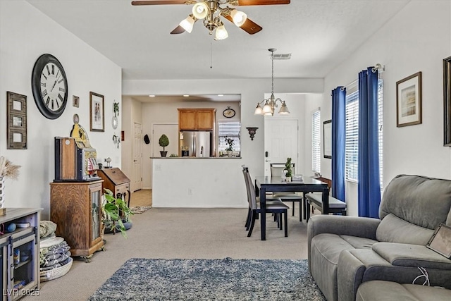 carpeted dining space with ceiling fan with notable chandelier