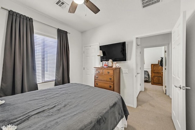 bedroom featuring multiple windows, light carpet, and ceiling fan