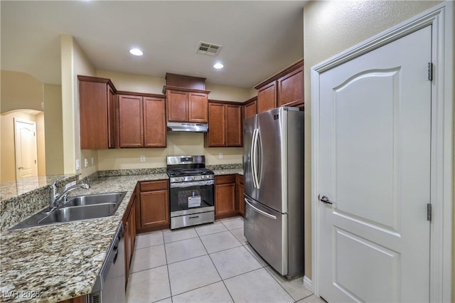 kitchen featuring light stone countertops, stainless steel appliances, sink, kitchen peninsula, and light tile patterned flooring