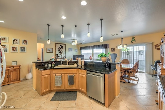 kitchen with pendant lighting, dishwasher, sink, light tile patterned floors, and dark stone counters