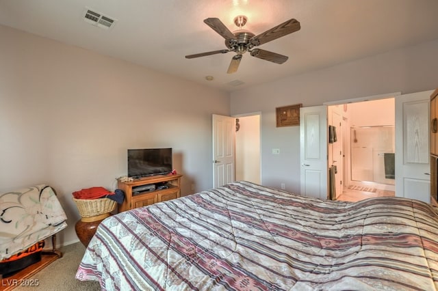 bedroom with ceiling fan, ensuite bathroom, and carpet flooring