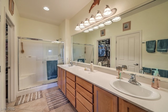 bathroom with tile patterned flooring, walk in shower, and vanity