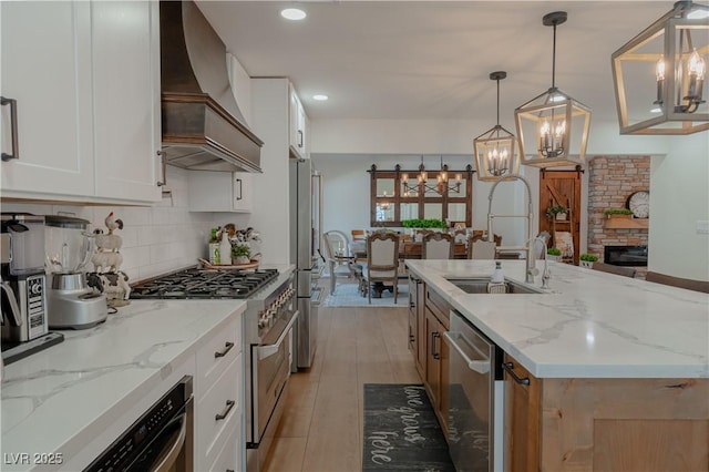 kitchen with pendant lighting, white cabinetry, and custom range hood