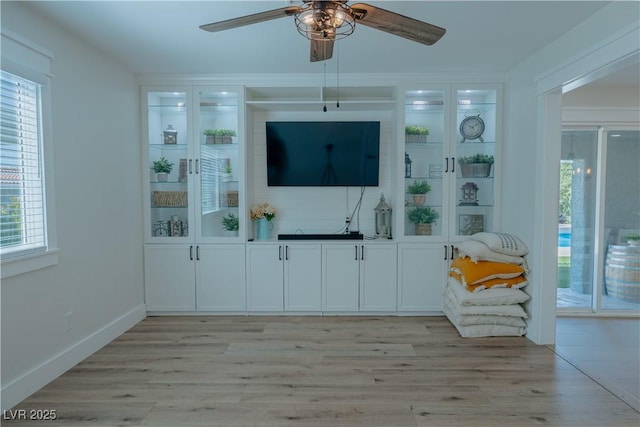 unfurnished living room with light wood-type flooring and ceiling fan