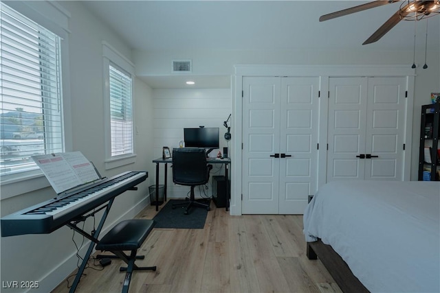 bedroom with multiple windows, light hardwood / wood-style flooring, and ceiling fan