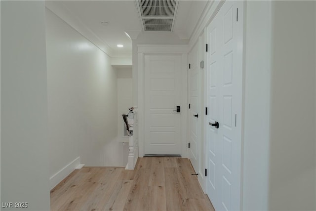 hall with crown molding and light hardwood / wood-style floors