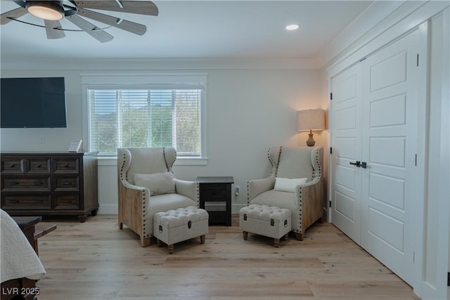 sitting room featuring crown molding, light wood-type flooring, and ceiling fan