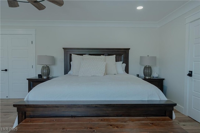 bedroom with wood-type flooring, ceiling fan, and crown molding