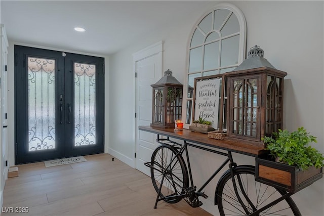 foyer featuring light hardwood / wood-style floors and french doors