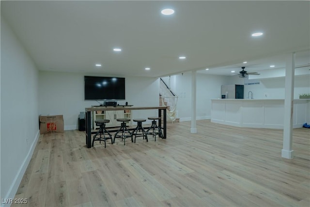 bar featuring sink, stainless steel fridge with ice dispenser, and light hardwood / wood-style flooring