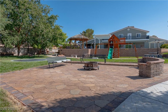 view of patio / terrace featuring a playground, an outdoor fire pit, and a gazebo