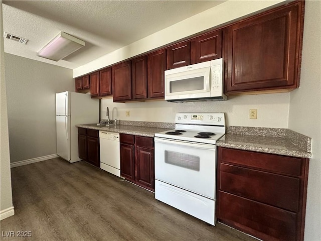 kitchen with sink, white appliances, dark hardwood / wood-style floors, and a textured ceiling