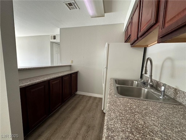 kitchen featuring sink, a textured ceiling, and dark hardwood / wood-style flooring