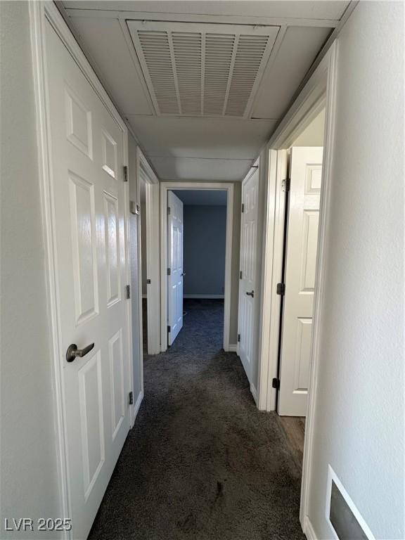 hallway featuring dark colored carpet