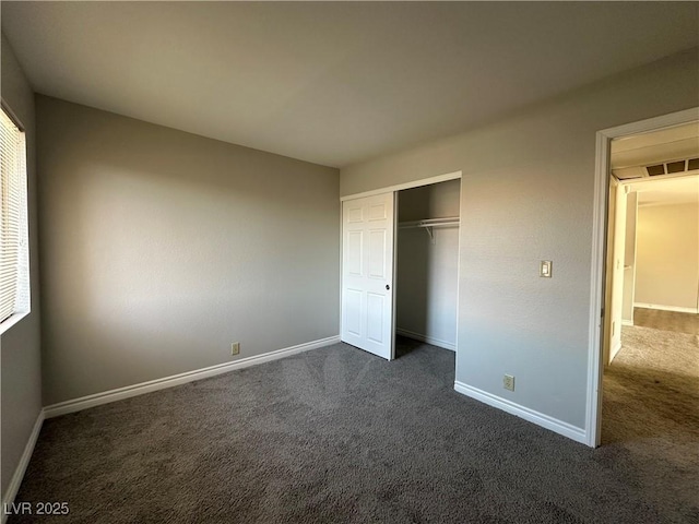 unfurnished bedroom featuring a closet and dark colored carpet