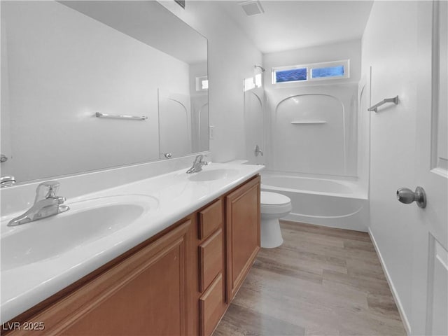 full bathroom featuring vanity, bathing tub / shower combination, hardwood / wood-style floors, and toilet