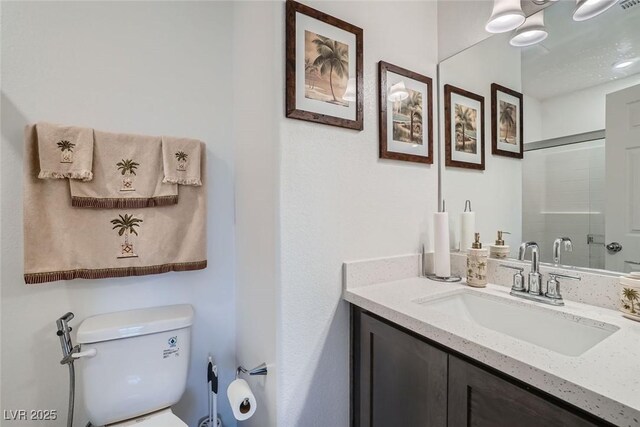 bathroom with toilet, a shower with shower door, and vanity