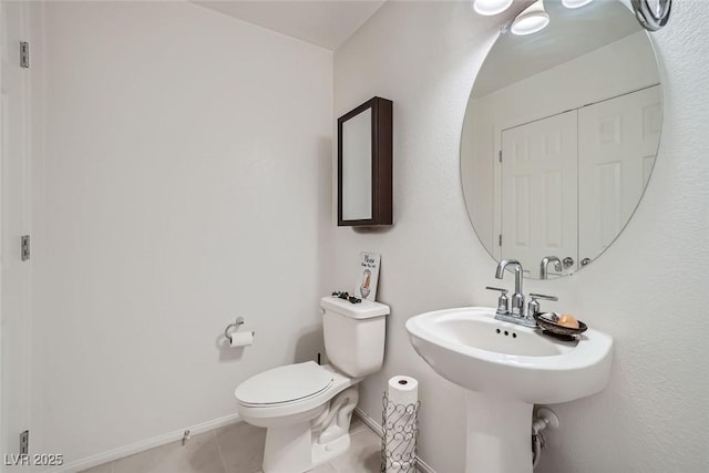 bathroom with toilet and tile patterned flooring