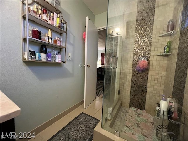 bathroom with walk in shower, vanity, and tile patterned flooring