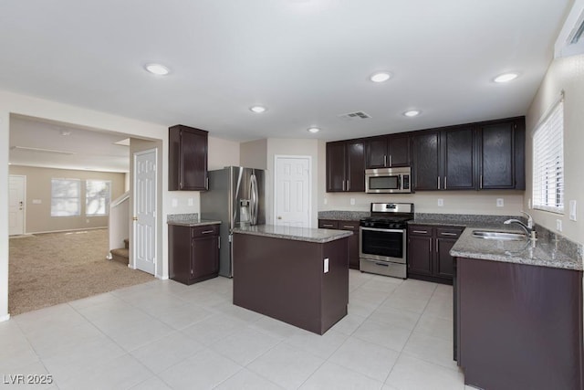 kitchen with light stone counters, a sink, stainless steel appliances, visible vents, and recessed lighting
