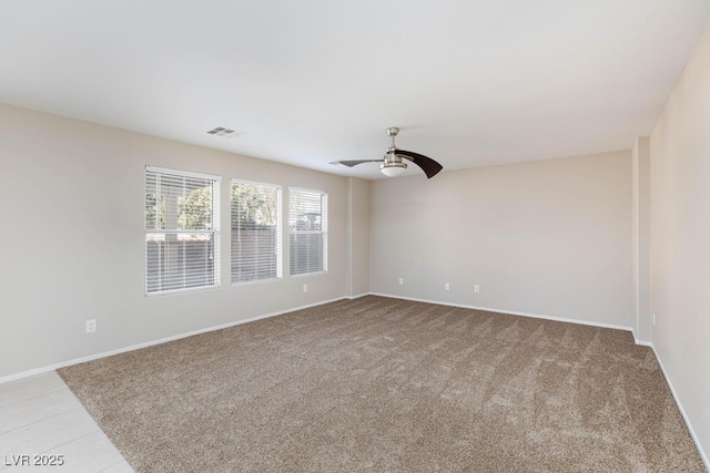 spare room with visible vents, baseboards, ceiling fan, and light colored carpet