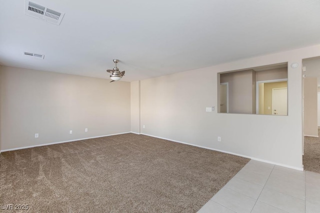 carpeted spare room with baseboards, tile patterned flooring, and visible vents