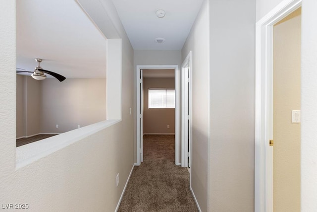 hallway with carpet floors and baseboards
