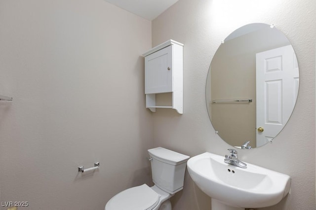 half bathroom featuring a sink and toilet
