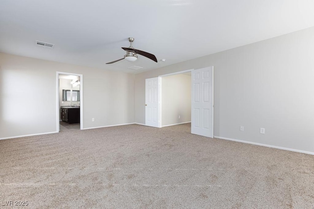 carpeted empty room featuring baseboards, a ceiling fan, and visible vents