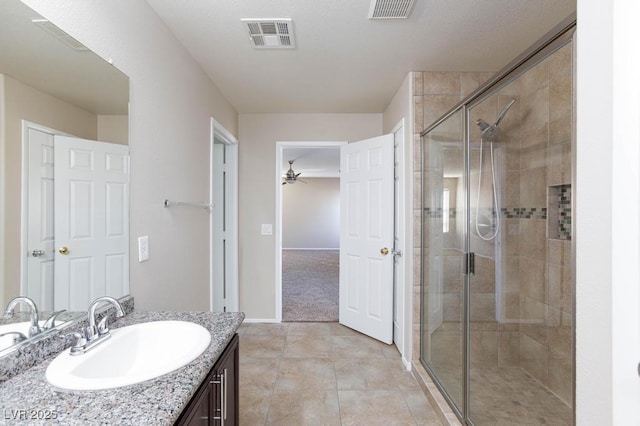 bathroom featuring visible vents, vanity, ceiling fan, and a stall shower