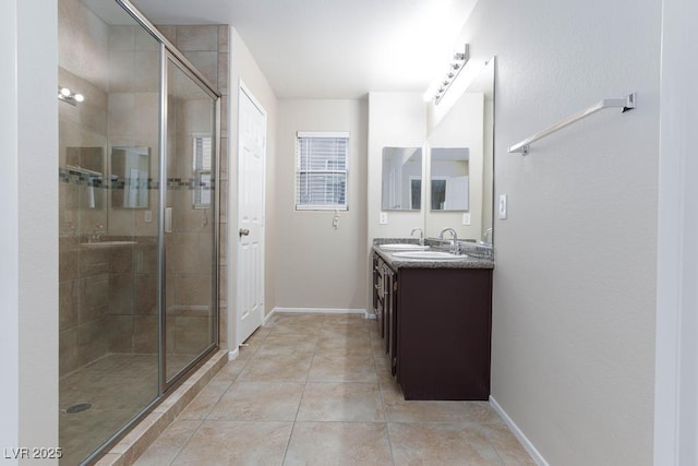 bathroom featuring baseboards, vanity, tile patterned floors, and a stall shower