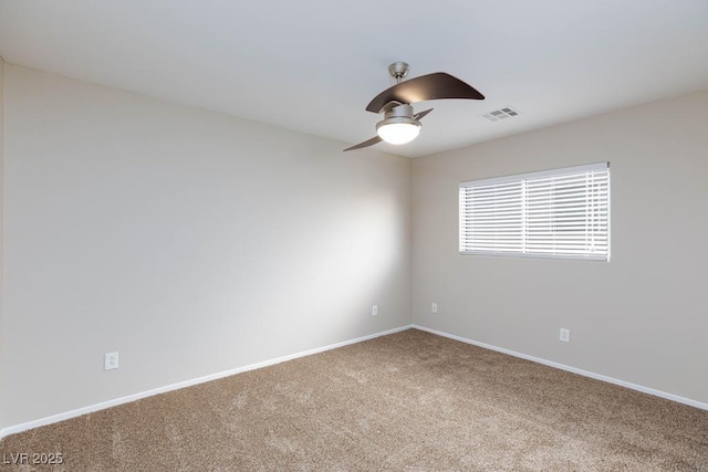 carpeted spare room featuring visible vents, baseboards, and ceiling fan