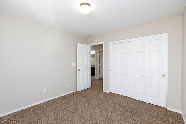 unfurnished bedroom with baseboards, carpet flooring, and a closet