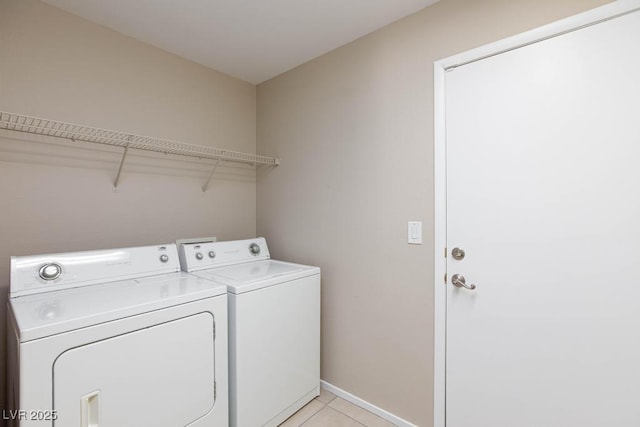 laundry area featuring washing machine and dryer, baseboards, laundry area, and light tile patterned floors