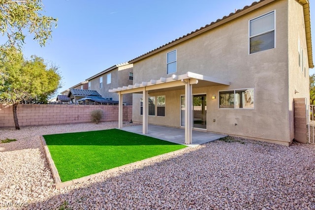 back of property with a fenced backyard, a yard, a patio, and stucco siding