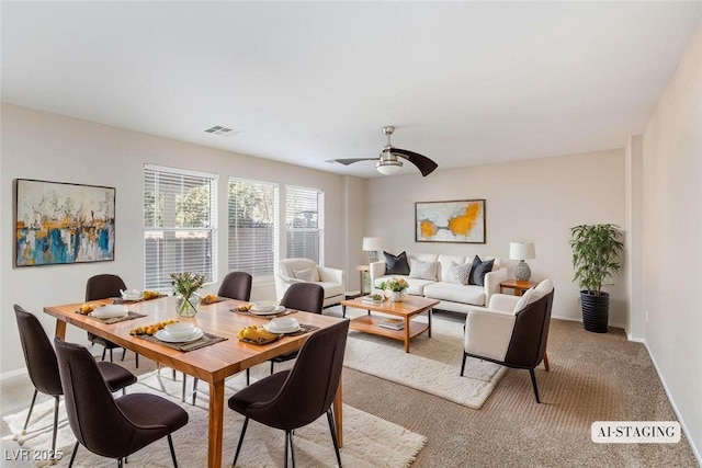 dining space with ceiling fan, baseboards, visible vents, and light carpet