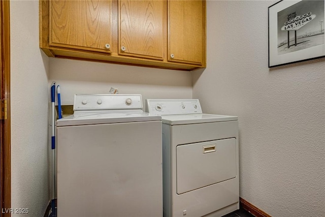 clothes washing area featuring cabinets and washer and dryer