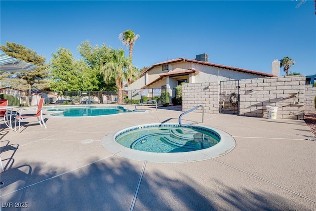 view of swimming pool with cooling unit, a hot tub, and a patio