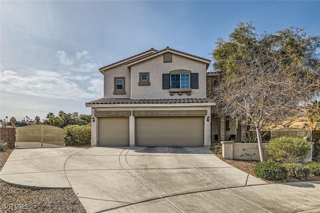 mediterranean / spanish home featuring stucco siding, a tile roof, a gate, concrete driveway, and an attached garage