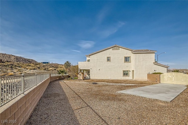 view of home's exterior with a gate, stucco siding, a fenced backyard, and a patio area