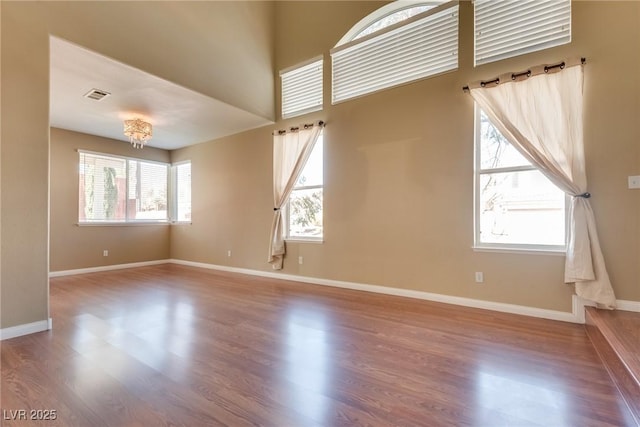 unfurnished room with hardwood / wood-style flooring and a healthy amount of sunlight