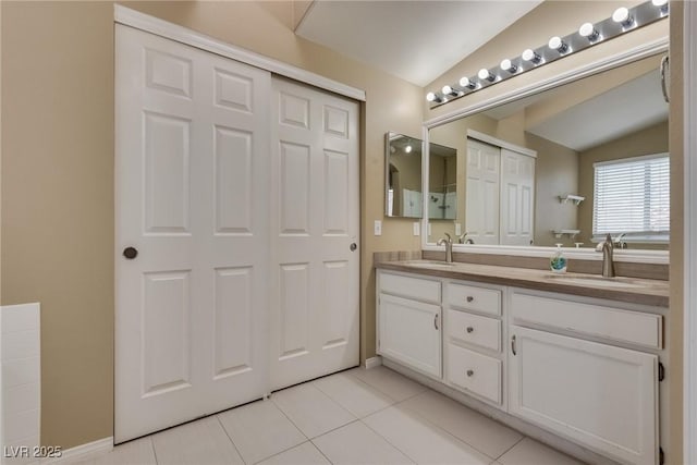 bathroom with vanity, lofted ceiling, and tile patterned flooring