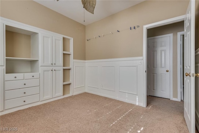 unfurnished bedroom featuring light carpet, a closet, and ceiling fan