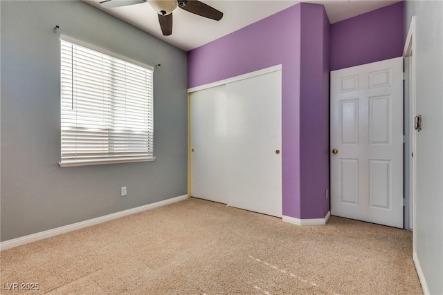 unfurnished bedroom featuring ceiling fan, light colored carpet, and a closet