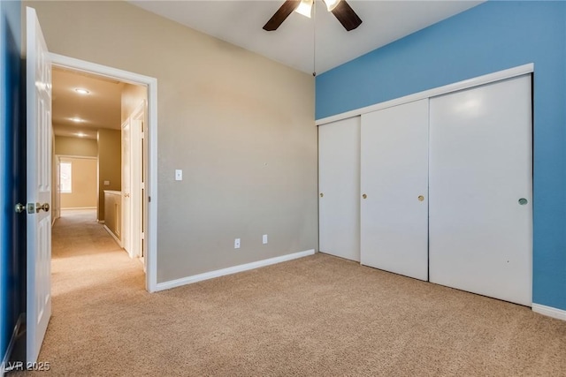 unfurnished bedroom with a closet, ceiling fan, and light colored carpet