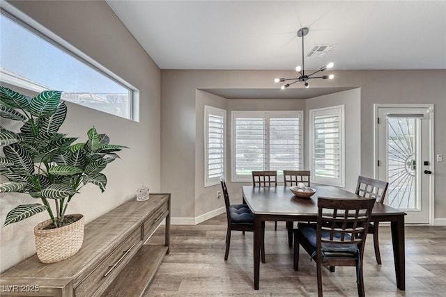 dining space featuring hardwood / wood-style floors and an inviting chandelier